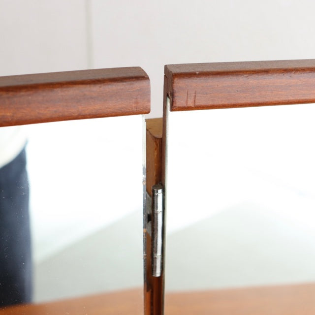 Close-up of vintage teak wood dressing table hinge with rich grain and mid-century British craftsmanship details.