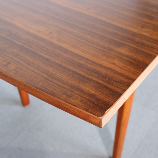 Vintage British mid-century teak dining table with rich wood grain and tapered legs from Denmark.