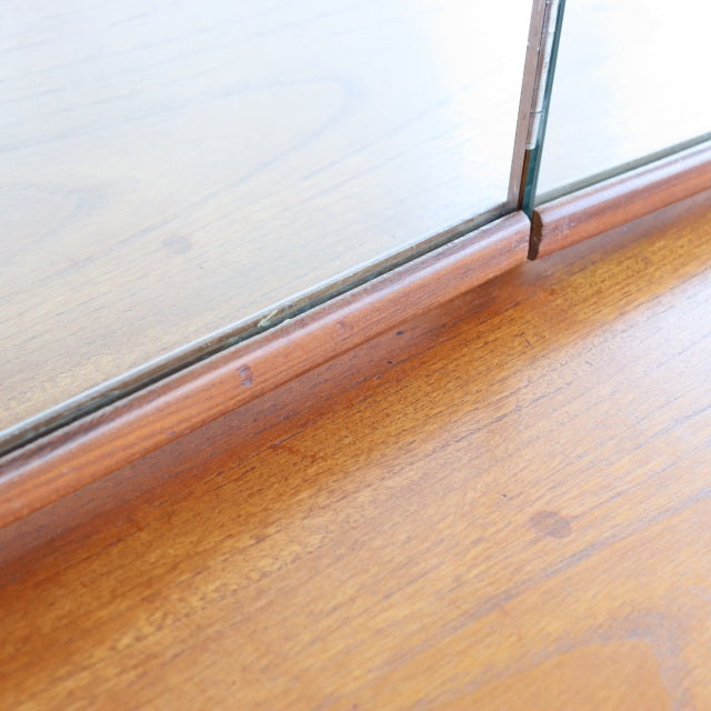 Close-up of vintage teak woodgrain on British mid-century dresser with sleek rounded edges and smooth finish.
