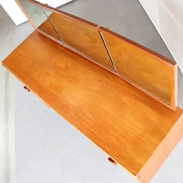 Vintage mid-century teak dresser with British and Danish design influences, featuring clean wood grain and angled legs.