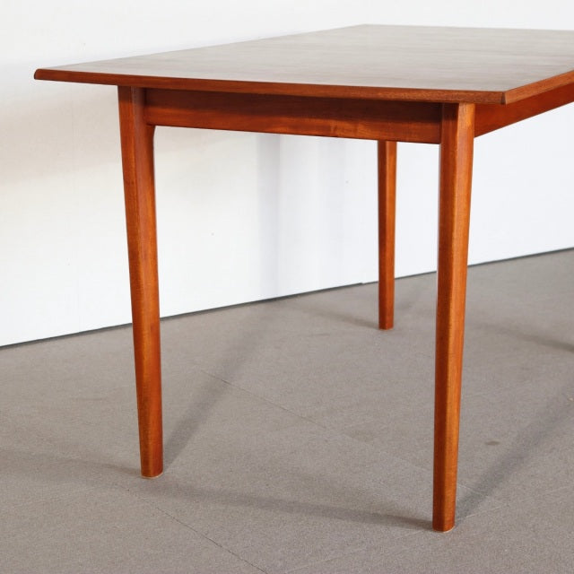 Vintage mid-century British teak dining table with rectangular top, smooth wood grain, and tapered legs from Denmark.