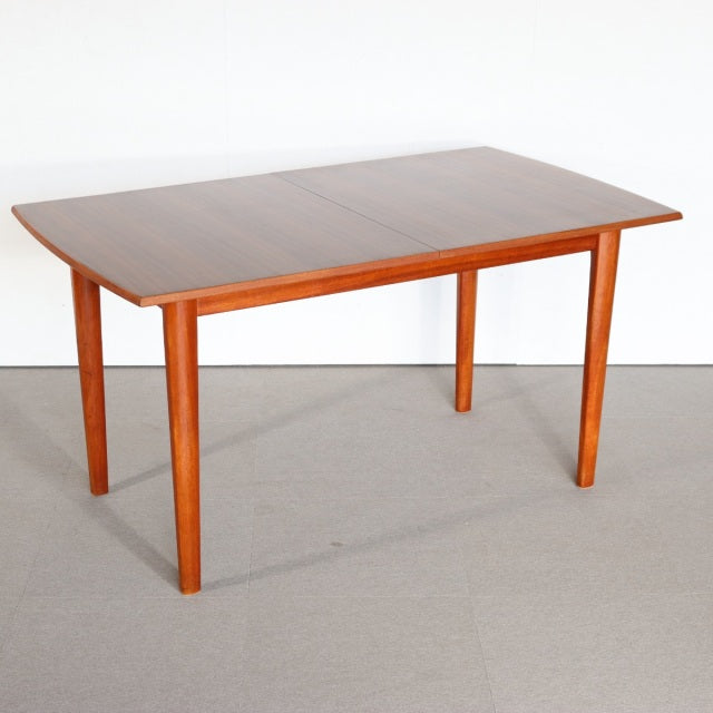 Mid-century vintage British teak dining table with rectangular top, smooth wood grain, and tapered legs from Denmark.