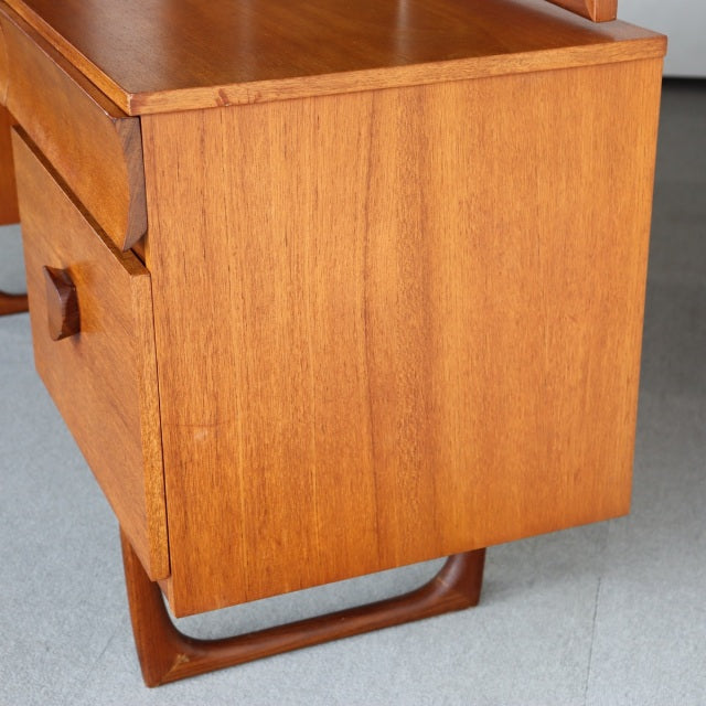 Vintage teak mid-century British dresser with sleek wood grain, rounded edges, and Danish-inspired curved legs.