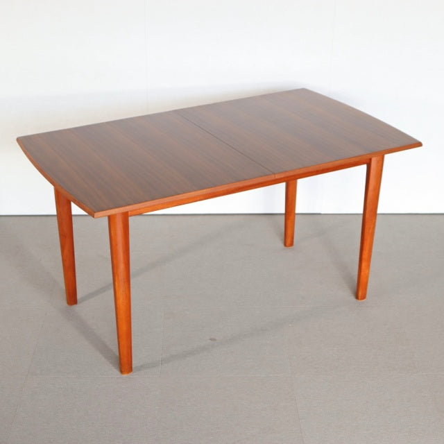 Vintage teak rectangular dining table with smooth wood grain, slender British mid-century legs, Danish design influence,.