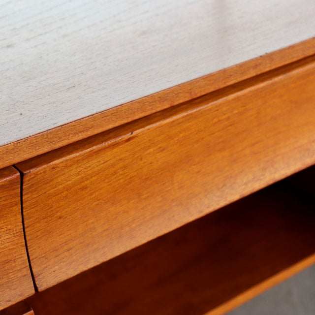 Close-up of vintage British mid-century teak dresser corner showcasing smooth wood grain and seamless drawer edge from.