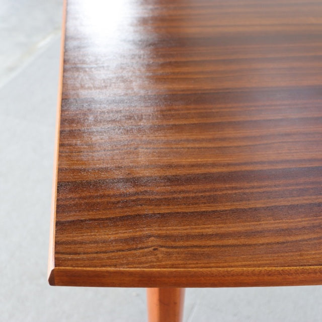Vintage British mid-century teak dining table with rich wood grain and sleek rectangular edges.
