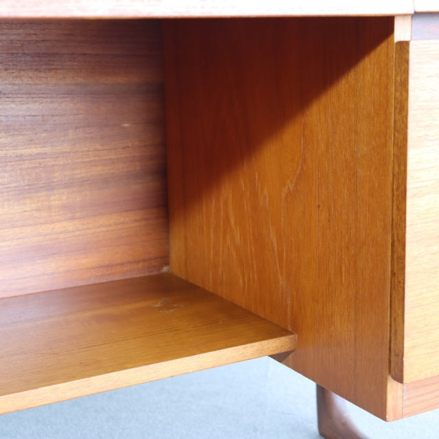 Close-up of vintage teak dressing table corner showing rich wood grain and clean mid-century British design with slender.