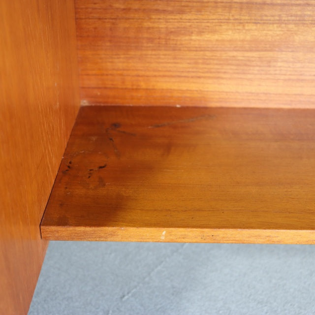Close-up of vintage teak wood surface on mid-century British-Danish dresser with smooth grain and warm honey tones.