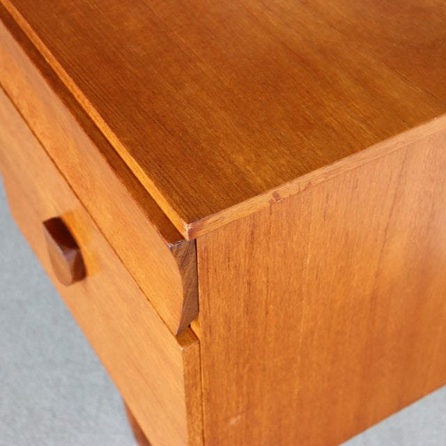 Close-up of vintage mid-century teak dresser corner with visible wood grain and British-Denmark design details.