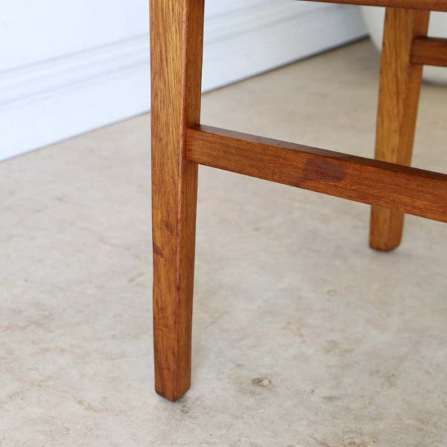 Close-up of teak dining chair leg showcasing warm wood grain and mid-century British vintage craftsmanship.