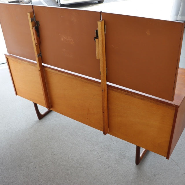 Vintage teak mid-century British dresser with smooth wood grain, angled legs, and clean-lined form from Durable Suites.