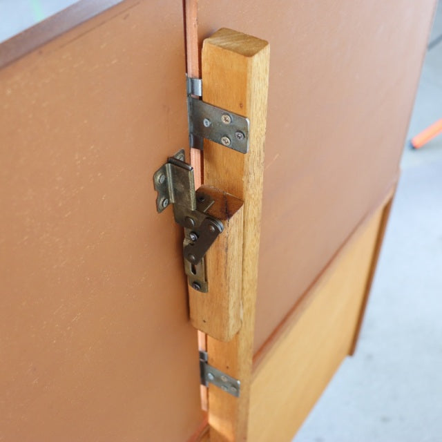 Close-up of vintage teak wood dresser hinge showcasing British mid-century craftsmanship and smooth wood grain from Durable.