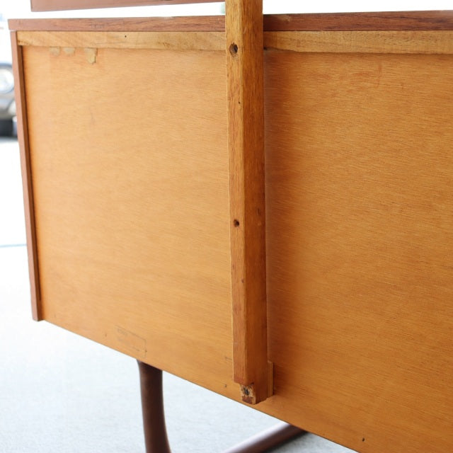 Vintage teak wood British mid-century dresser with smooth grain, clean lines, and slender tapered legs from Denmark.