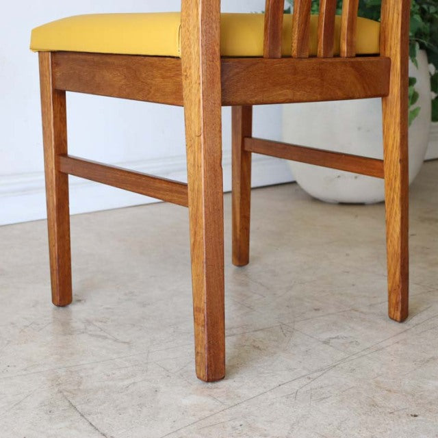 Mid-century teak dining chair with yellow upholstered seat, solid wood legs, vintage British design from Denmark.