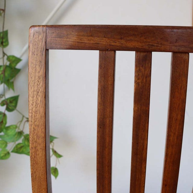 Mid-century British teak dining chair with yellow upholstered seat, vertical slat back, and tapered legs.