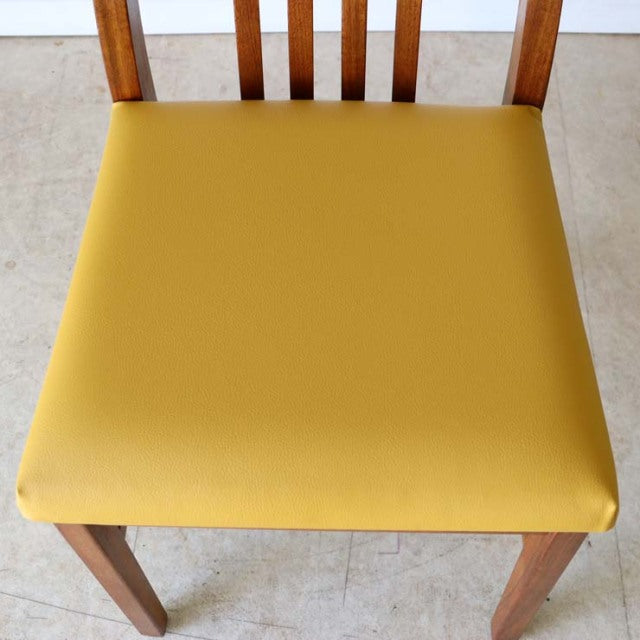 Mid-century British vintage teak dining chair with mustard yellow upholstered seat and slatted backrest.