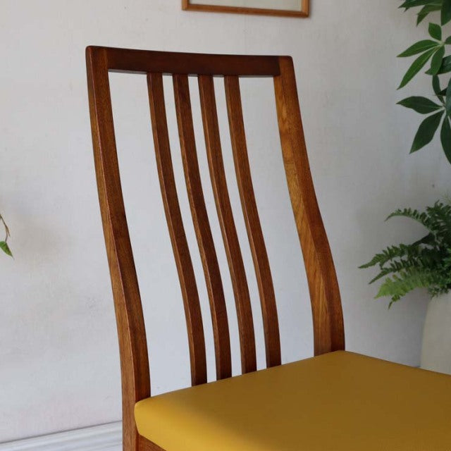 Mid-century vintage teak dining chair with curved slatted backrest and vibrant yellow upholstered seat, British design from.