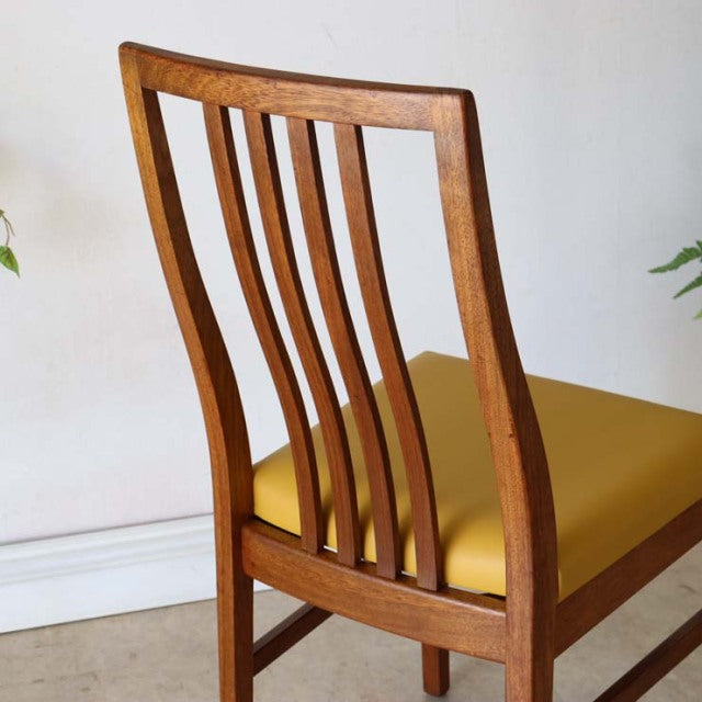 Vintage mid-century teak dining chair with curved slat backrest and mustard yellow upholstered seat, British-Danish design.