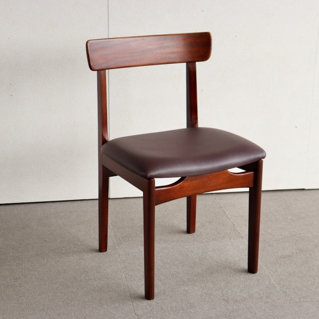 Vintage British mid-century teak dining chair with curved backrest and brown leather seat upholstery.