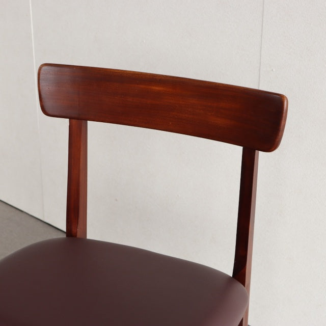 Vintage British mid-century teak dining chair with curved backrest and smooth wood grain, upholstered seat visible.