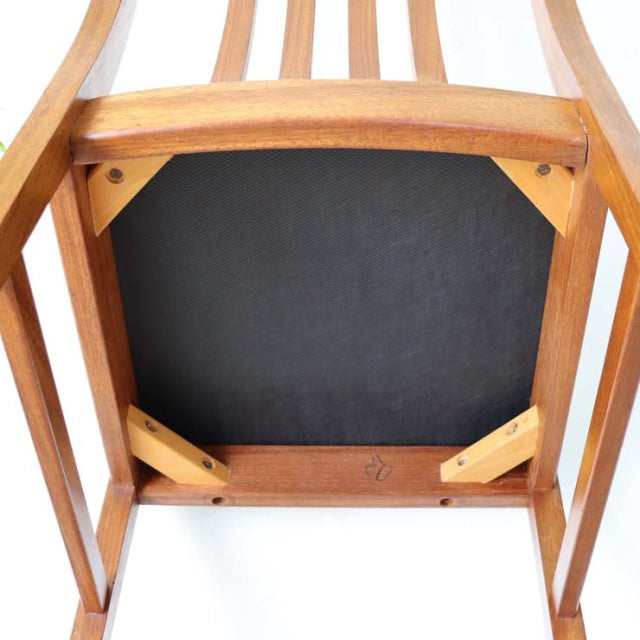 Mid-century vintage teak dining chair from Denmark, visible wood grain, sturdy angled legs, well-crafted frame with black.