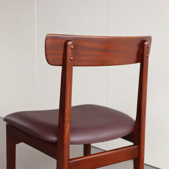 Vintage mid-century British dining chair in teak with smooth dark brown leather seat and curved backrest.