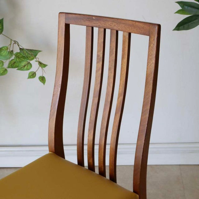 Mid-century vintage teak dining chair with vertical slat back and yellow seat cushion, British-Denmark design.