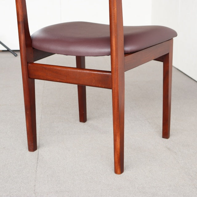Mid-century vintage teak dining chair with rich wood grain, British design, cushioned brown seat, slender legs.