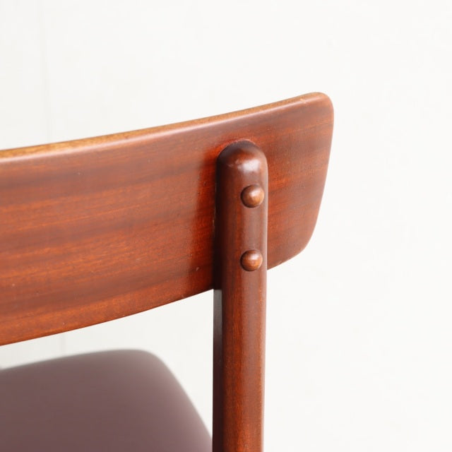 Mid-century vintage British teak dining chair backrest with smooth wood grain and rounded wooden dowel joints.