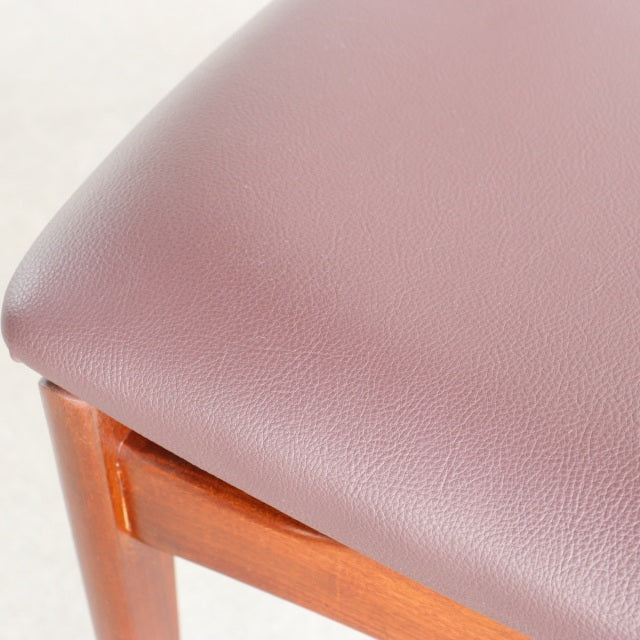 Vintage British mid-century teak dining chair with smooth wood grain and mauve leather seat upholstery.