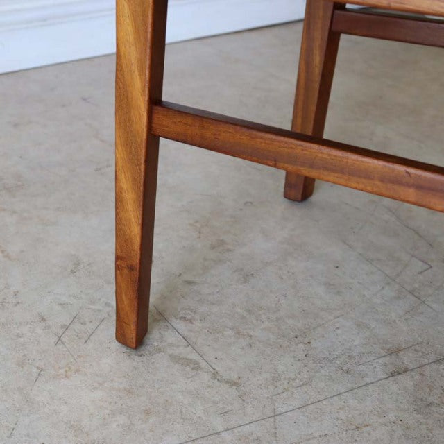 Mid-century British vintage teak dining chair legs with visible wood grain and sturdy frame on concrete floor.