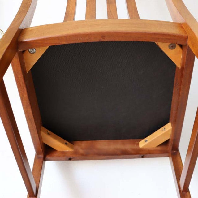 Vintage teak mid-century British dining chair with yellow cushioned seat, visible wood grain and sturdy legs, Scandinavian.