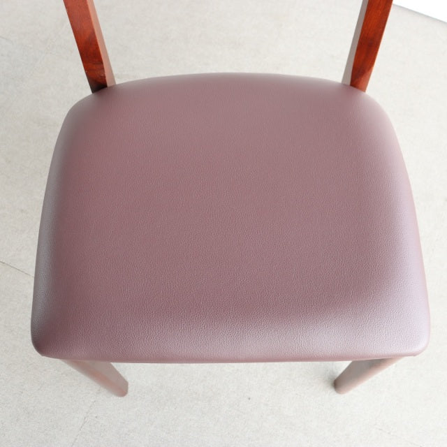 Vintage mid-century teak dining chair with smooth leather upholstery and sleek wooden legs from British-Denmark design.