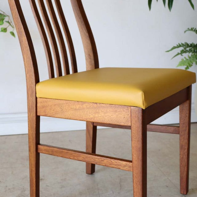 Vintage British mid-century teak dining chair with mustard yellow upholstered seat and curved slatted backrest.