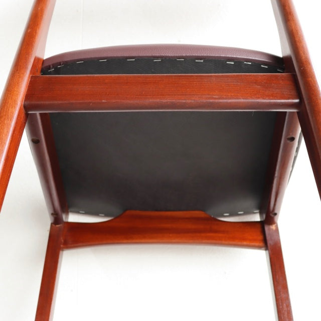 Mid-century British vintage teak dining chair showing smooth wood grain and solid leg construction from underneath.