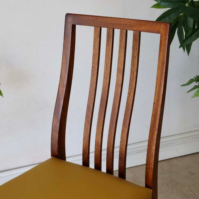 Mid-century British vintage teak dining chair with vertical slat back and vibrant yellow seat cushion in good condition.
