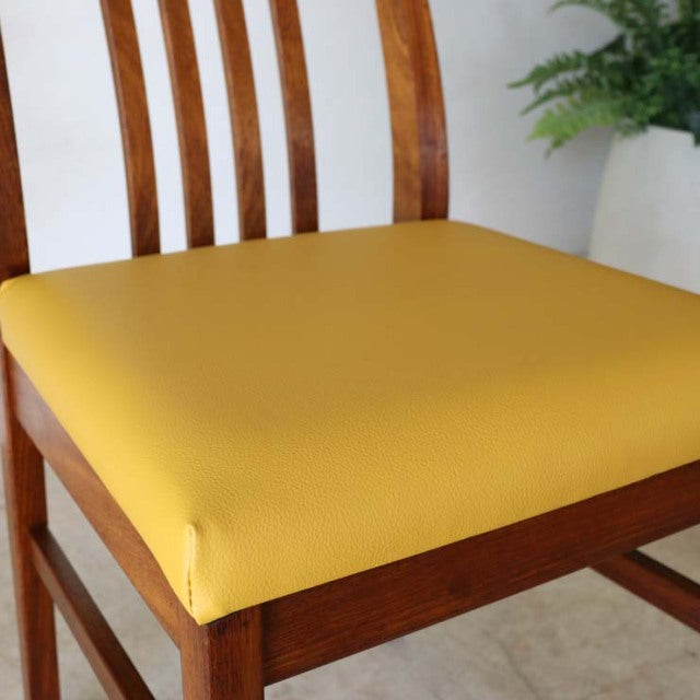 Vintage British mid-century teak dining chair with curved slat back and vibrant yellow upholstered seat.