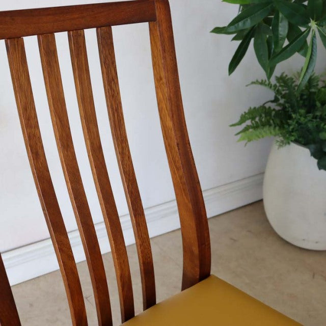 Mid-century British vintage teak dining chair with curved vertical slats and yellow seat cushion.