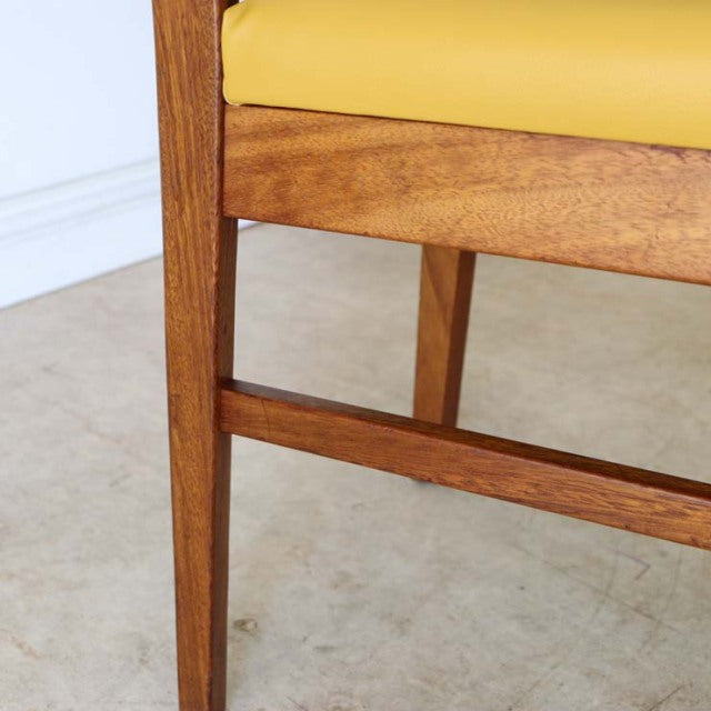 Mid-century British vintage teak dining chair with yellow upholstered seat and clean wood grain finish.