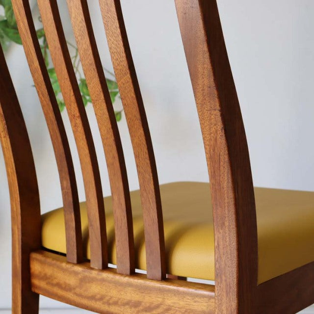 Mid-century British vintage teak dining chair with curved slatted back and yellow upholstered seat.