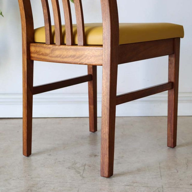 Mid-century British vintage teak dining chair with curved back slats and yellow upholstered seat.