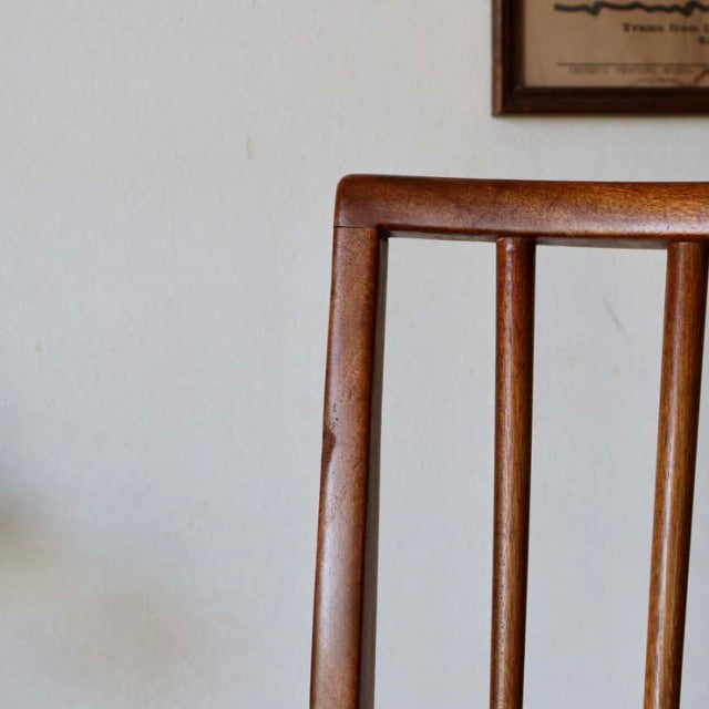 Vintage mid-century teak dining chair with sharp backrest and slender vertical slats, British-Denmark style with smooth wood .