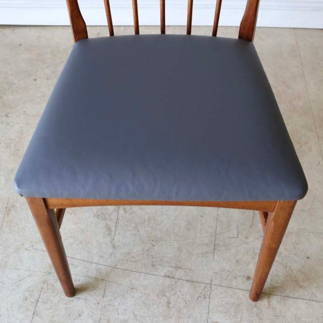 Mid-century British teak dining chair with vintage sharp back design and dark gray cushioned seat.
