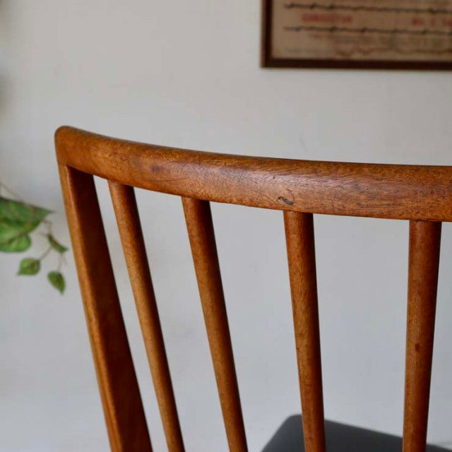 Vintage mid-century teak dining chair back with slender vertical spindles and smooth curved top rail, British-Denmark style.