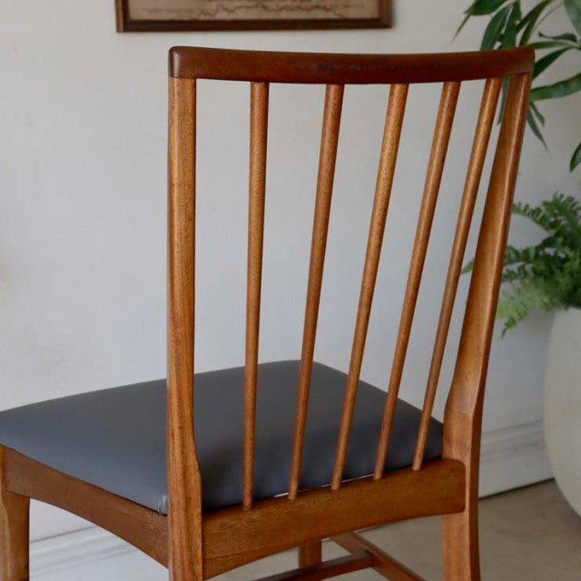 Vintage mid-century teak dining chair with slender vertical spindled backrest and dark upholstered seat, British-Denmark.
