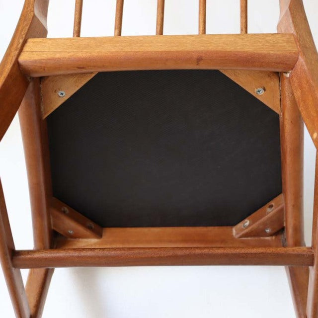 Vintage teak mid-century dining chair underside showing wooden frame with visible grain and sturdy corner reinforcements,.
