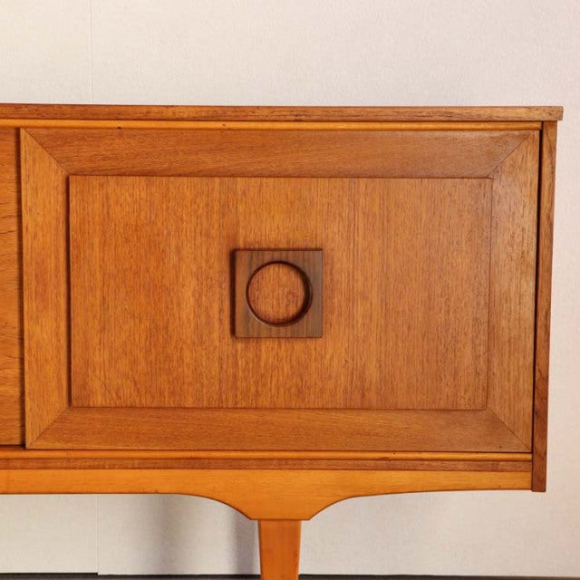 Mid-century British vintage teak sideboard with square recessed panel and circular wooden handle, smooth wood grain and.