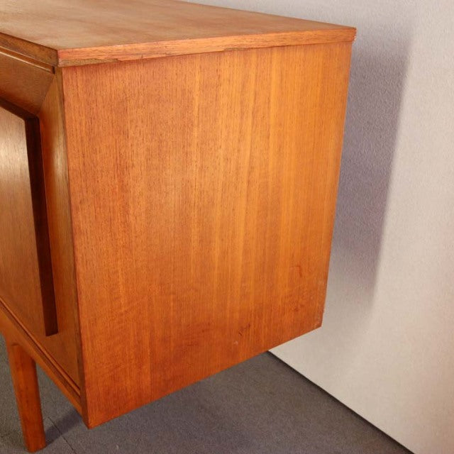 Mid-century British vintage teak sideboard with clean lines, tapered legs, and smooth wood grain finish.