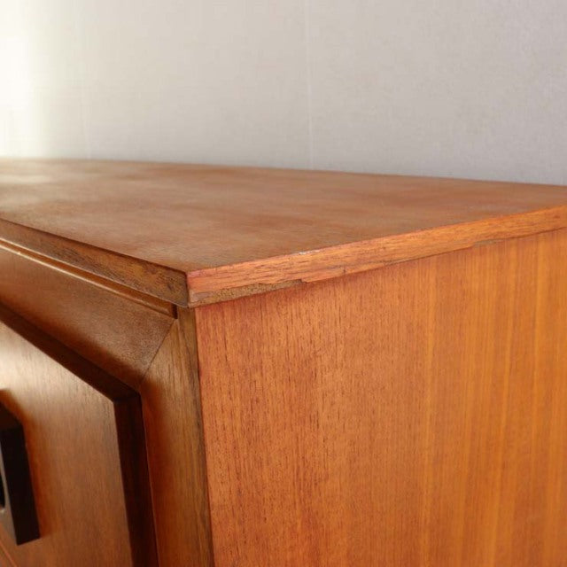 Vintage mid-century teak sideboard with rich wood grain and clean, angular edges, British-Danish design influence visible in .