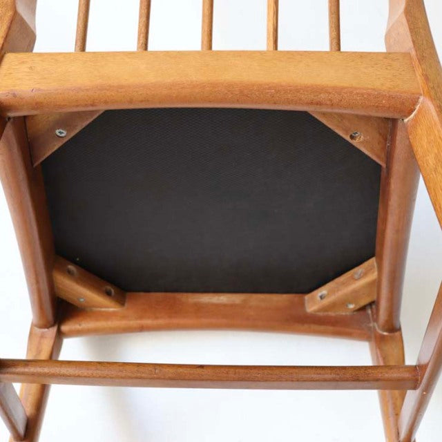 Vintage mid-century teak dining chair from British Denmark, showing sturdy wood frame and grain details underneath seat.